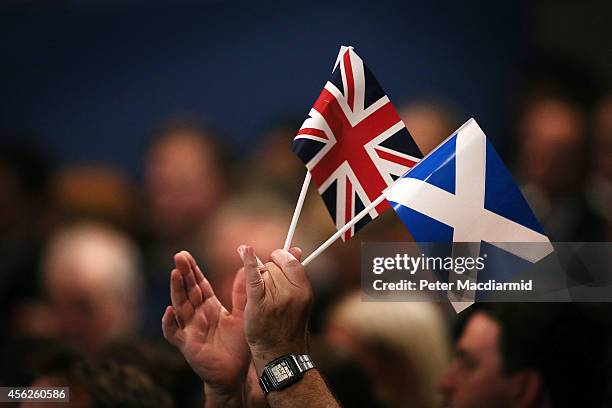 Delegate applauds speeches at the Conservative party conference holding both a Union and Scottish Saltire flag on September 28, 2014 in Birmingham,...