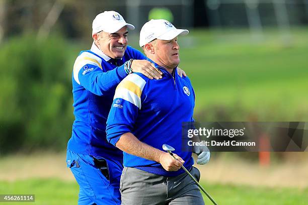 Jamie Donaldson of Europe is congratulated by Europe team captain Paul McGinley on the 15th hole shortly before Europe won the Ryder Cup after...