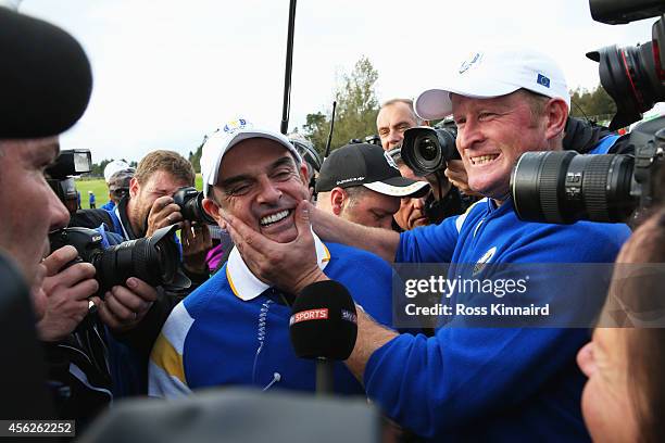 Jamie Donaldson of Europe and Europe team captain Paul McGinley celebrate on the 15th hole after Europe won the Ryder Cup with Donaldson defeating...