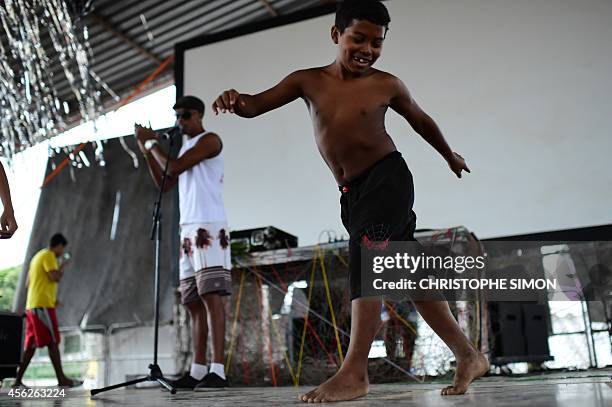 Child dances on the stage before the film projection at Brazilian-French "Planeta Ginga" film and music free festival at the Cidade de Deus...