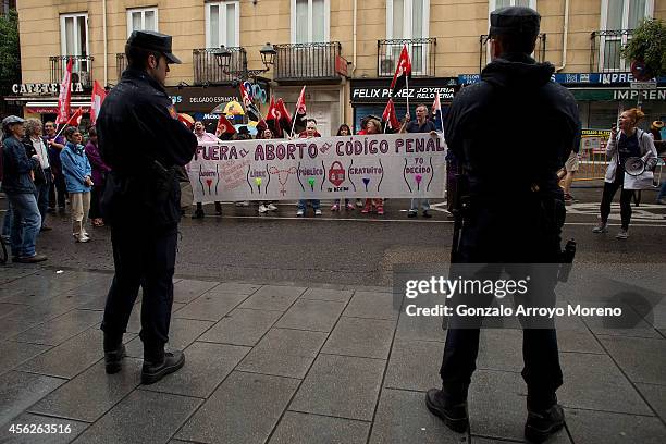 People hold a sign claiming to treat abortion not as a crime in front of the Spanish Justice Ministry during a demonstration supporting reproductive...