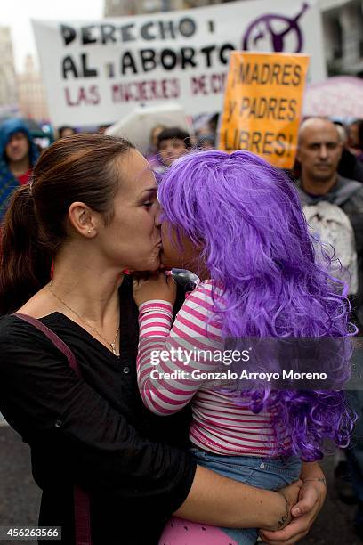 Woman kissses a child during a demonstration supporting reproductive rights for women on September 28, 2014 in Madrid, Spain. During an international...