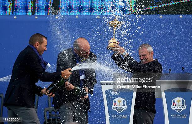 Europe team captain Paul McGinley lifts the Ryder Cup trophy as he is sprayed with champagne by Sergio Garcia of Europe after the Singles Matches of...