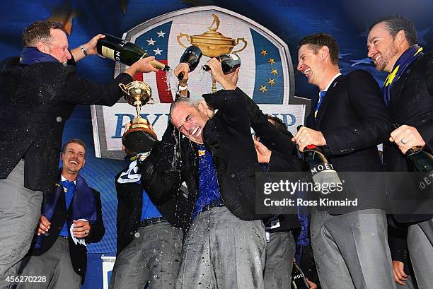 Europe team captain Paul McGinley lifts the Ryder Cup trophy as he is sprayed with champagne by Jamie Donaldson of Europe after the Singles Matches...