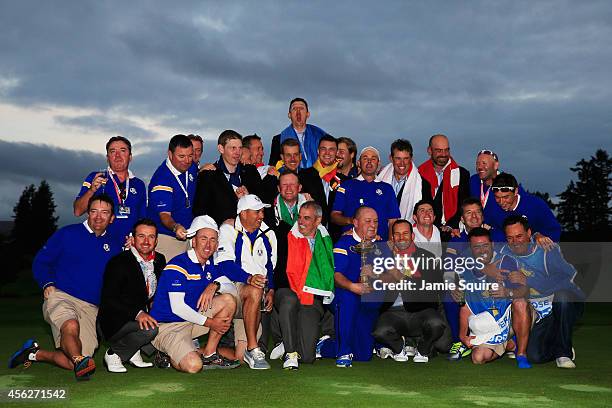 Europe team captain Paul McGinley celebrates winning the Ryder Cup trophy with his team and their caddies after the Singles Matches of the 2014 Ryder...