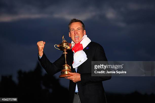 Ian Poulter of Europe celebrates with the Ryder Cup trophy after the Singles Matches of the 2014 Ryder Cup on the PGA Centenary course at the...