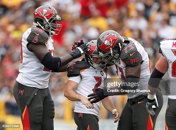 Patrick Murray of the Tampa Bay Buccaneers celebrates his 50 yard field goal with Demar Dotson and Anthony Collins during the first quarter against...