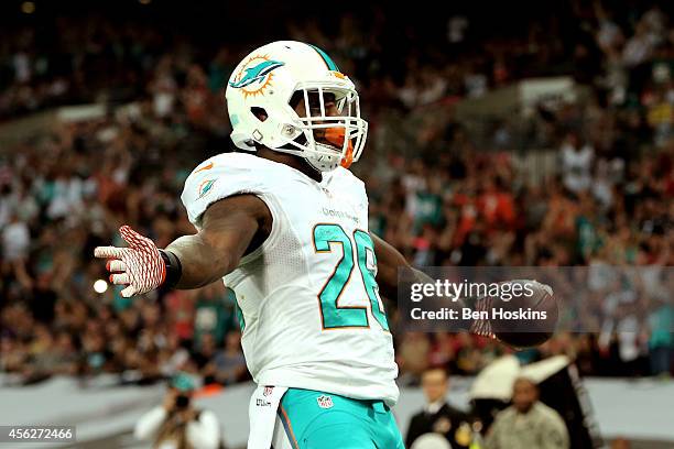 Lamar Miller of the Miami Dolphins scores his team's second touchdown on a nine yard rush during the NFL match between the Oakland Raiders and the...