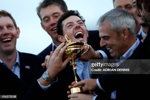 Rory McIlroy of Northern Ireland and Captain of Team Europe Paul McGinley of Ireland pose with the trophy after retaining the Ryder Cup on the final...