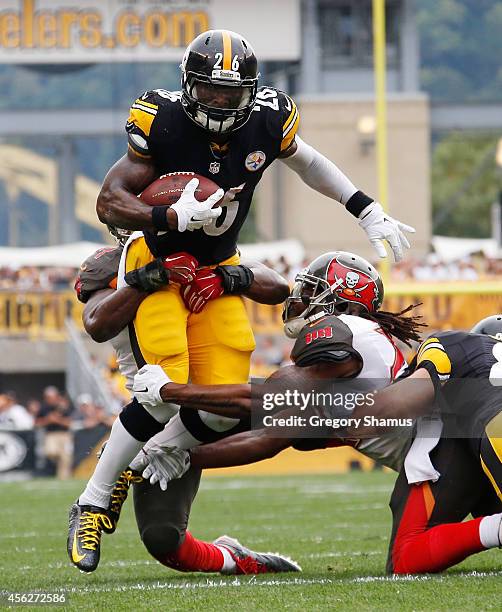 Le'Veon Bell of the Pittsburgh Steelers gets dragged down by Jacquies Smith and Mark Barron of the Tampa Bay Buccaneers during the first quarter at...