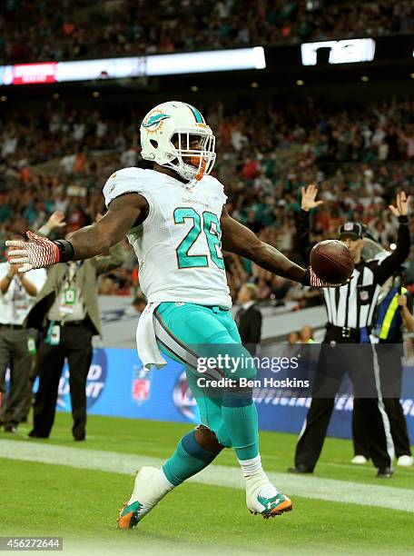 Lamar Miller of the Miami Dolphins scores his team's second touchdown on a nine yard rush during the NFL match between the Oakland Raiders and the...