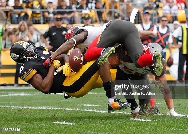 Justin Brown of the Pittsburgh Steelers can't make a catch after being hit by Alterraun Verner and Dane Fletcher of the Tampa Bay Buccaneers during...