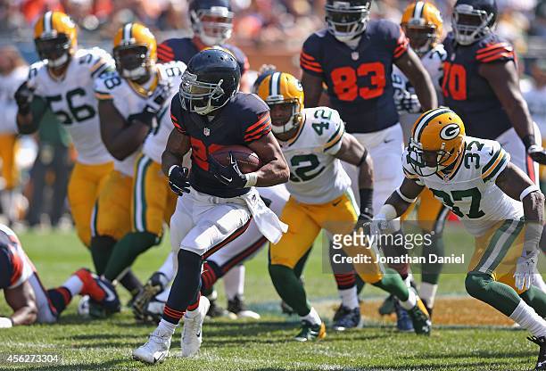 Matt Forte of the Chicago Bears runs from defenders Julius Peppers of the Green Bay Packers, Letroy Guion of the Green Bay Packers, Morgan Burnett of...