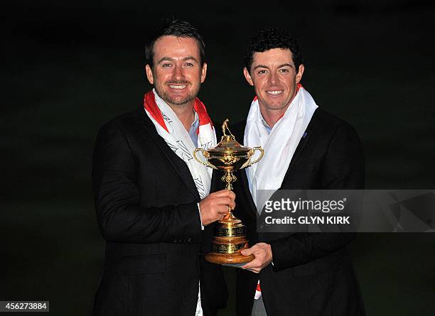 Graeme McDowell of Northern Ireland and Rory McIlroy of Northern Ireland pose for photographs after Team Europe retained the Ryder Cup on the final...