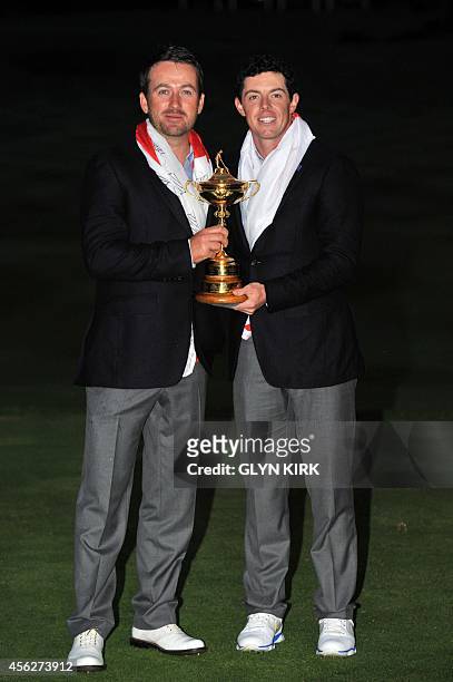 Graeme McDowell of Northern Ireland and Rory McIlroy of Northern Ireland pose for photographs after Team Europe retained the Ryder Cup on the final...
