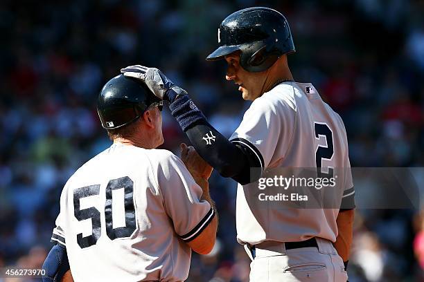 Derek Jeter speaks with Mick Kelleher of the New York Yankees after hitting a single for his last career at bat in the third inning against the...