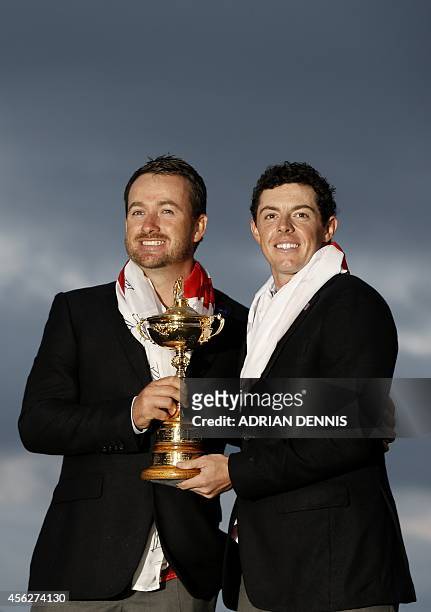 Graeme McDowell of Northern Ireland and Rory McIlroy of Northern Ireland pose with the trophy after Team Europe retained the Ryder Cup on the final...