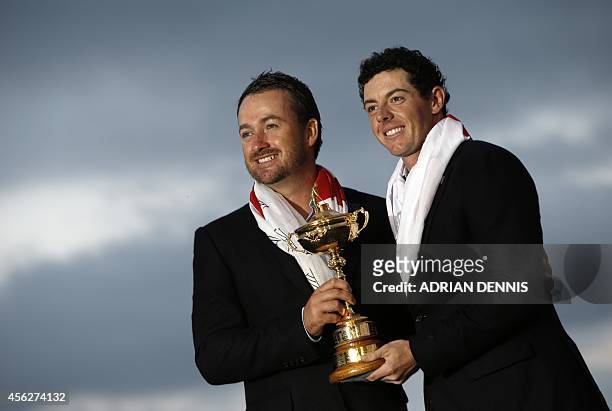Graeme McDowell of Northern Ireland and Rory McIlroy of Northern Ireland pose with the trophy after Team Europe retained the Ryder Cup on the final...