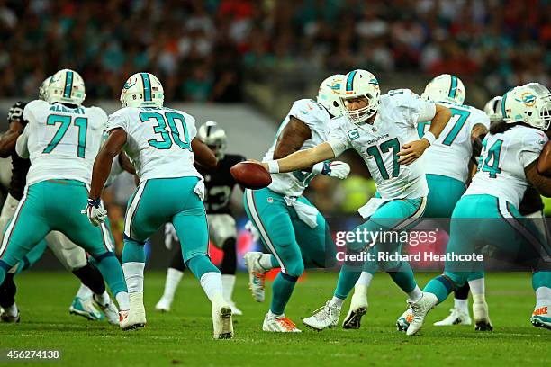 Ryan Tannehill of the Miami Dolphins hands off to Daniel Thomas of the Miami Dolphins during the NFL match between the Oakland Raiders and the Miami...