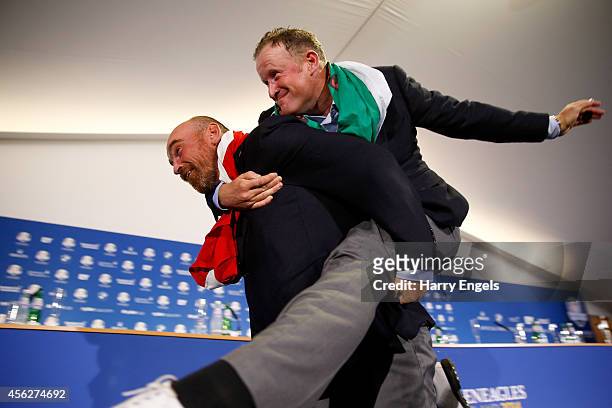 Thomas Bjorn of Europe carries Jamie Donaldson into the press conference after the Singles Matches of the 2014 Ryder Cup on the PGA Centenary course...