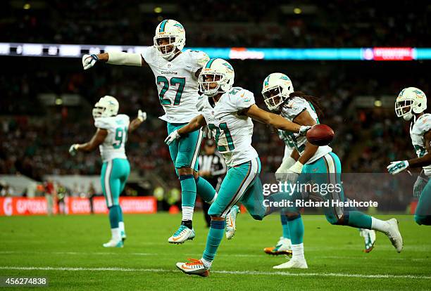 Brent Grimes of the Miami Dolphins celebrates with teammates after returning an interception for big yardage during the NFL match between the Oakland...