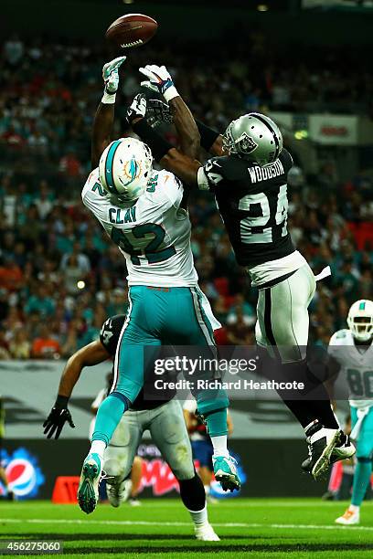 Charles Woodson of the Oakland Raiders breaks up a pass intended for Charles Clay of the Miami Dolphins during the NFL match between the Oakland...