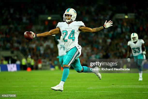 Cortland Finnegan of the Miami Dolphins returns a fumble 50 yards to score a touchdown during the NFL match between the Oakland Raiders and the Miami...