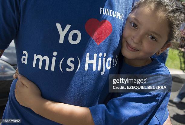 Young girl hugs her father wearing a T-shirt reading "I love my children", during a protest demanding equal rights regarding alimony payments, in San...