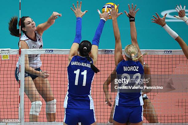 Kelly Murphy of USA spikes as Ekaterina Gamova and Regina Moroz of Russia block during the FIVB Women's World Championship pool C match between USA...