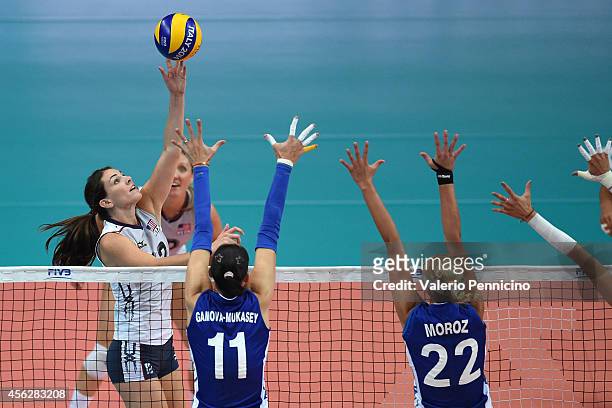 Kelly Murphy of USA spikes as Ekaterina Gamova and Regina Moroz of Russia block during the FIVB Women's World Championship pool C match between USA...