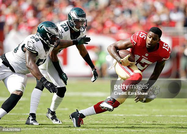 Michael Crabtree of the San Francisco 49ers runs away from Trent Cole and Cary Williams of the Philadelphia Eagles after Williams pulled Crabree's...