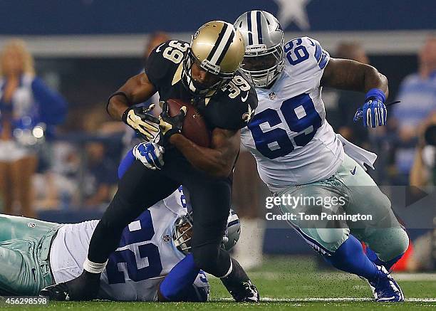 Travaris Cadet of the New Orleans Saints is tackled by Jeremy Mincey of the Dallas Cowboys and Henry Melton of the Dallas Cowboys in the first half...