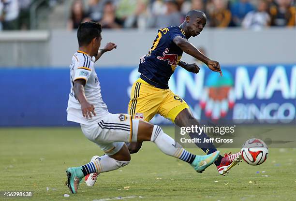 Bradley Wright-Phillips of New York Red Bulls shoots the ball while defended by A.J. DeLaGarza of Los Angeles Galaxy in the first half at StubHub...