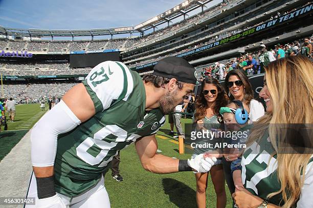 Wide Receiver Eric Decker of the New York Jets visits with his wife, Jessie James Decker and their baby when she attends the Detroit Lions vs New...