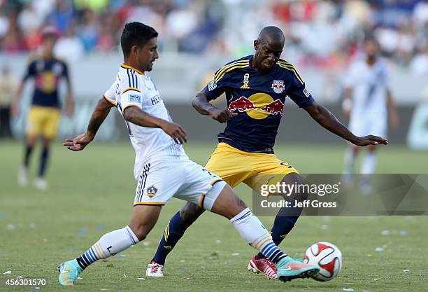Bradley Wright-Phillips of New York Red Bulls is challenged for the ball by A.J. DeLaGarza of Los Angeles Galaxy in the first half at StubHub Center...