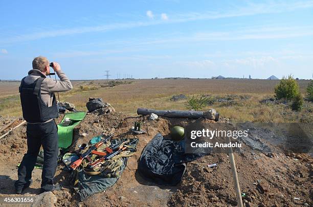 Member of Ukrainian security forces looks through binoculars at a checkpoint in Debaltseve where pro-Russian separatists stage assaults, in Ukraine...