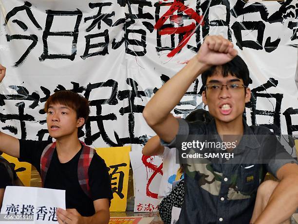 Two Hong Kong students who studies in Taiwan chant slogans in front of a poster reading "Hong Kong's today will be Taiwan's tomorrow" during a...