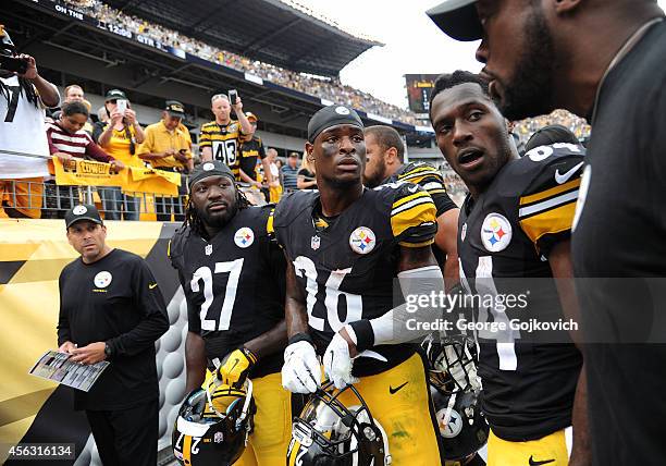 Head coach Mike Tomlin of the Pittsburgh Steelers talks to running backs LeGarrette Blount and Le'Veon Bell and wide receiver Antonio Brown as...