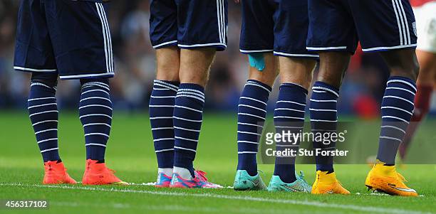 Players with a range of multi-coloured boots line up at a wall during the Barclays Premier League match between West Bromwich Albion and Burnley at...