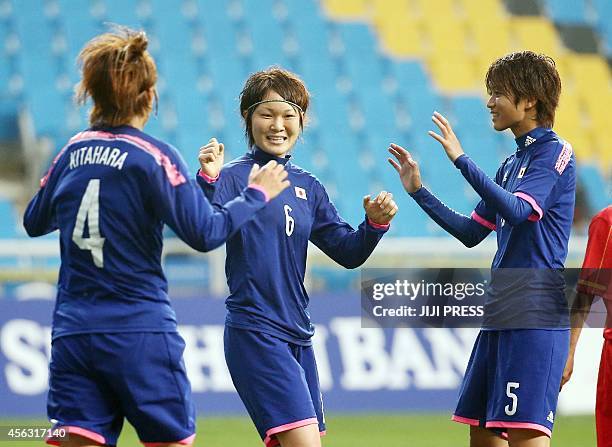 Japan's midfielder Mizuho Sakaguchi celebrates with her teammates Kana Kitahara and Kana Osafune after she scored a goal against Vietnam during the...