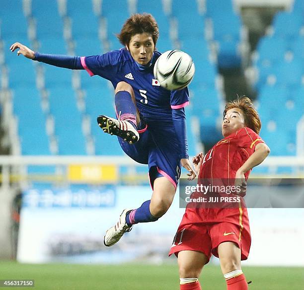 Japan's defender Kana Osafune and Vietnam's midfielder Nguyen Thi Yen fight for the ball during the women's football semi final at the 2014 Asian...