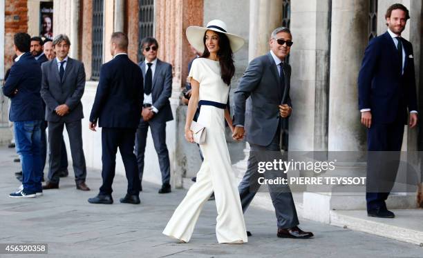 Actor George Clooney and British lawyer Amal Alamuddin arrive on September 29, 2014 at the palazzo Ca Farsetti in Venice, for a civil ceremony to...
