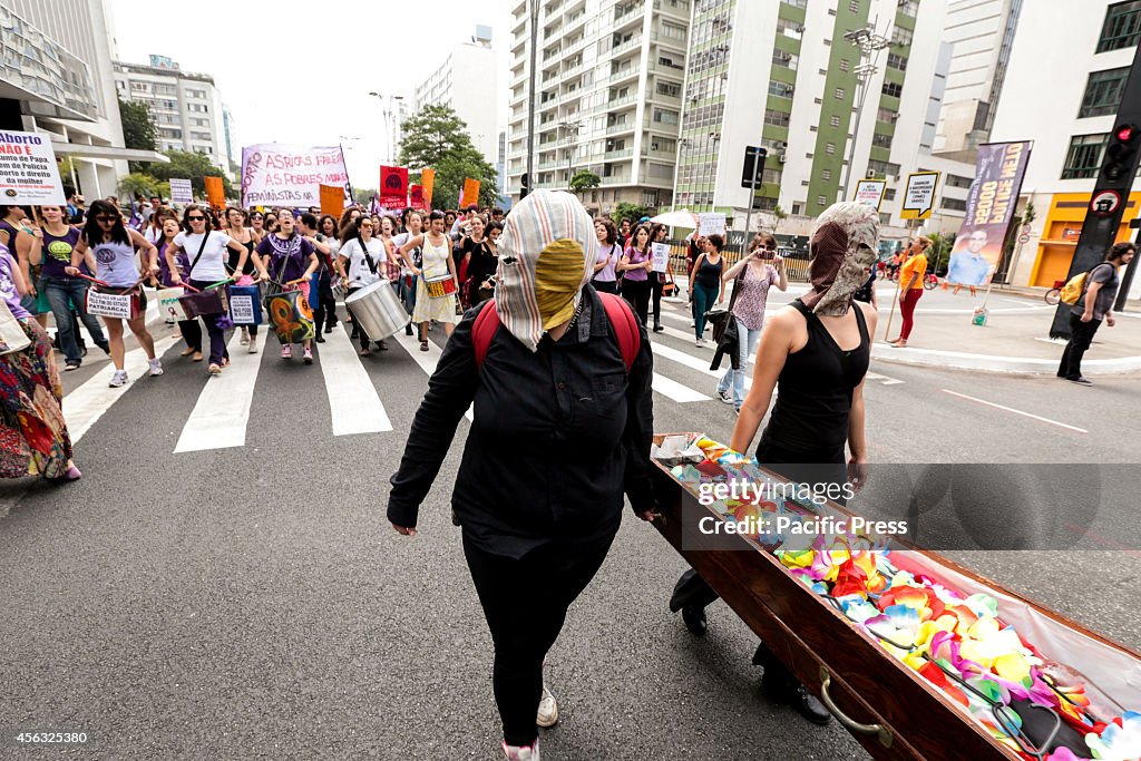 Women with masks hold a coffin symbolizing women who die...