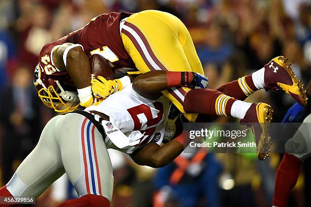 Tight end Niles Paul of the Washington Redskins is tackled by strong safety Antrel Rolle of the New York Giants in the first half at FedExField on...