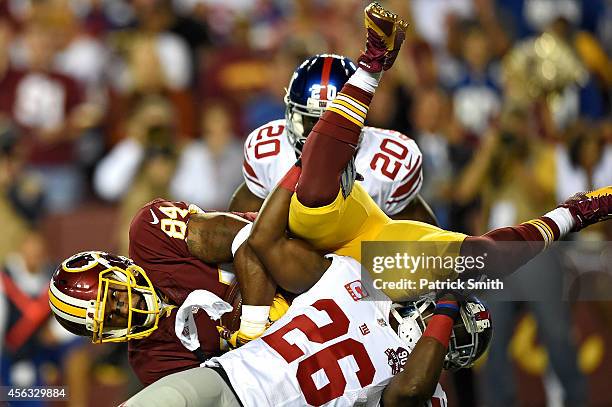 Tight end Niles Paul of the Washington Redskins is tackled by strong safety Antrel Rolle of the New York Giants in the first half at FedExField on...