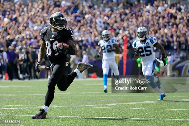 Wide receiver Steve Smith of the Baltimore Ravens carries the ball into the endzone for a touchdown after catching a pass in the first half against...