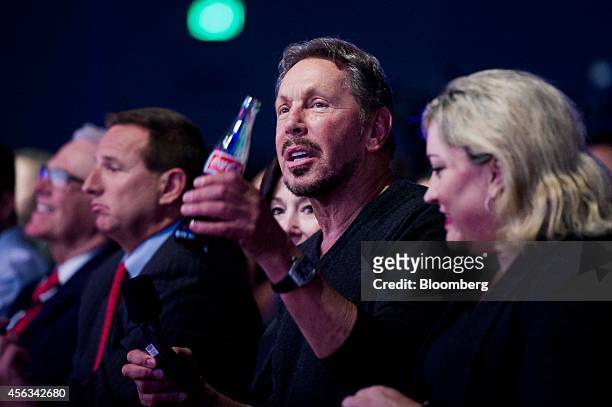 Larry Ellison, chairman of Oracle Corp., center watches a presentation during the Oracle OpenWorld 2014 conference in San Francisco, California,...