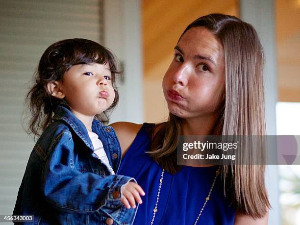 toddler and her aunt puffing out their cheeks - aunt stock-fotos und bilder