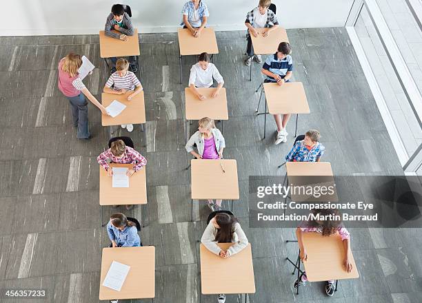 teacher handing out test papers to students - 12 13 anos - fotografias e filmes do acervo