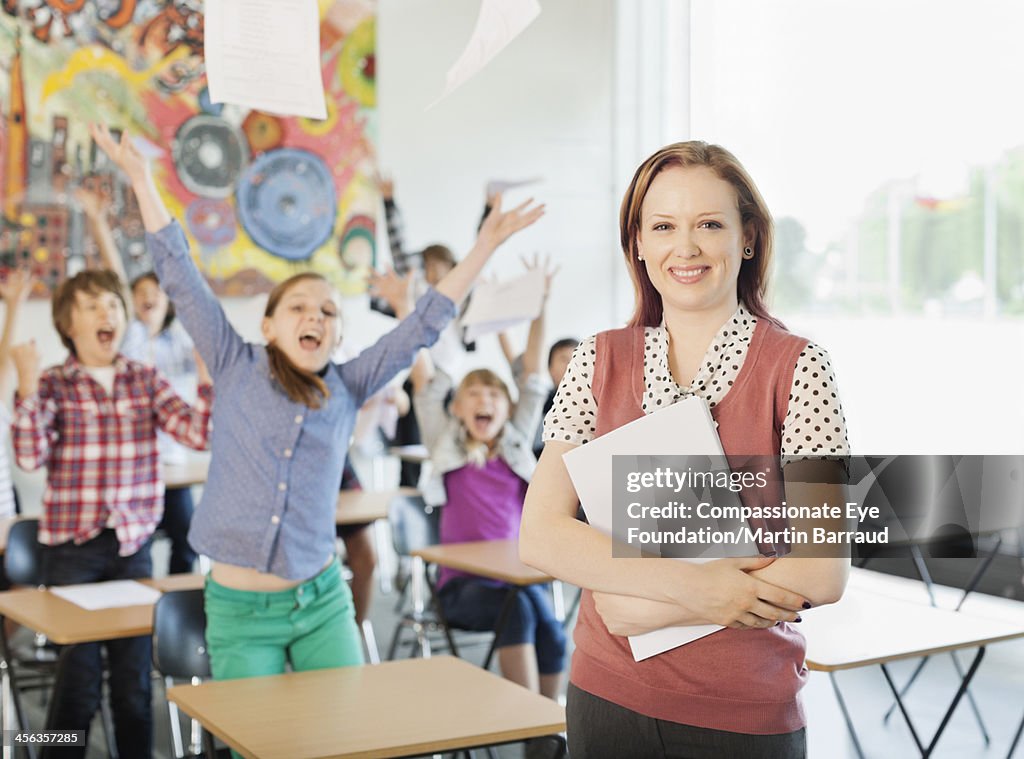 Teacher with celebrating students in classroom